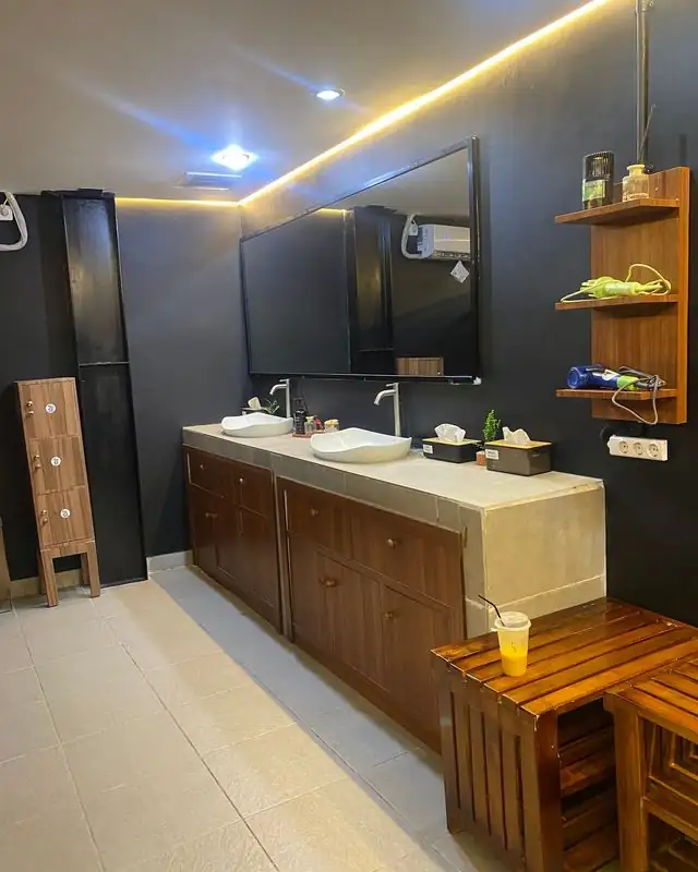 Restroom with wooden vanity and stone counter