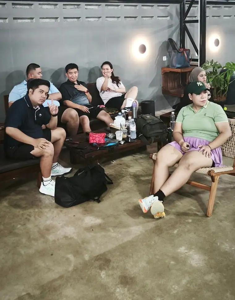 Friends relaxing on the lounge sofas beside the courts